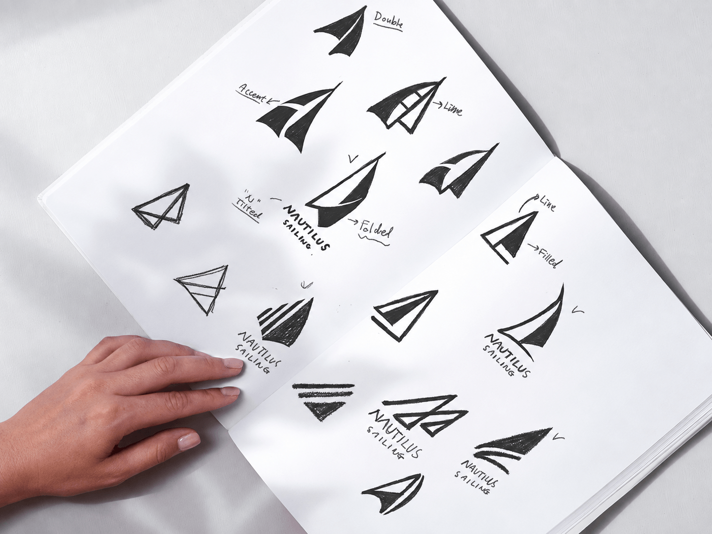 Sketchbook of hand-drawn Nautilus Sailing sail logo concepts